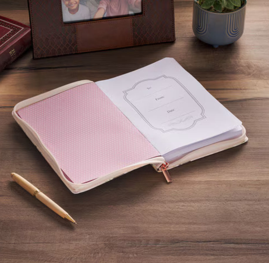 Pink floral faux leather journal with zipper closure by Christian Art Gifts, featuring a decorative floral design on the cover.